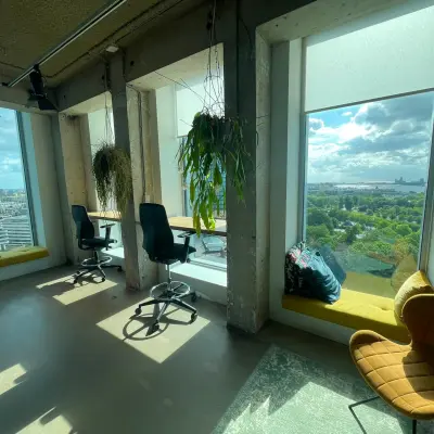 Kantoorruimte huren met panoramisch uitzicht op Amsterdam Noord vanaf Overhoeksplein 1, voorzien van comfortabele zithoek met planten.