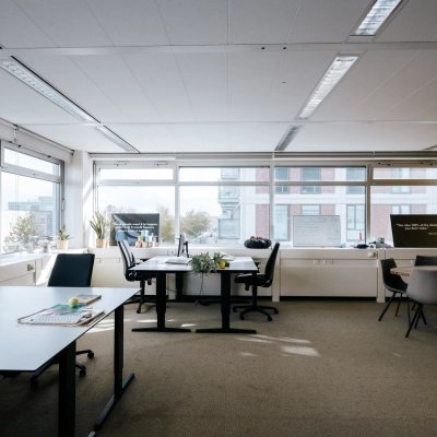 Lichte kantoorruimte op TT Vasumweg 44, Amsterdam Noord, met grote ramen en werkplekken met bureaus en stoelen. Ideaal voor wie een kantoor of kantoorpand wil huren.