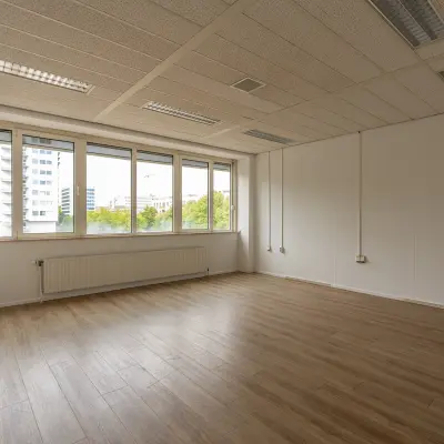 Leegstaande kantoorruimte te huur op James Wattstraat 71 in Amsterdam Oost, met grote ramen en een houten vloer. Ideaal voor een frisse start in een dynamische omgeving.