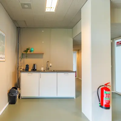 Een compacte pantry in een kantoorpand aan de James Wattstraat 71, Amsterdam Oost, met een klein aanrecht en enkele kasten. Kantoorruimte huren hier is eenvoudig en efficiënt.