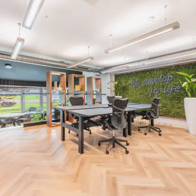 Moderne kantoorruimte met uitzicht op een groene ruimte, voorzien van werktafels en ergonomische stoelen in het Olympisch Stadion, Amsterdam Oud Zuid. Ideaal voor kantoorruimte huren met professionele ambiance.