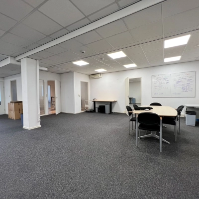 Kantoorruimte huren op Contactweg 131, Amsterdam Sloterdijk. Ruime, lichte open vloer met vergadertafel en kantoorstoelen, ideaal voor verschillende zakelijke activiteiten. Geschikt voor nieuwe huurders.