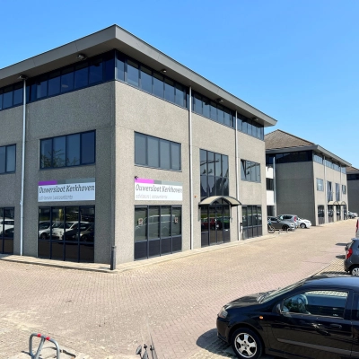 Buitenaanzicht van een kantoorpand op Dynamostraat 42 in Amsterdam Sloterdijk, met parkeerplaatsen op de voorgrond. Geschikt voor kantoorruimte huren.