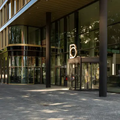 Buitenzijde van modern kantoorpand op Kon. Wilhelminaplein 4, Amsterdam West met glazen gevel en entree. Ideale locatie voor kantoorruimte huren in levendige omgeving.