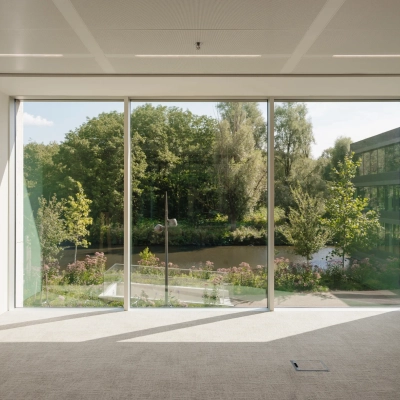 Kantoorruimte met grote ramen die uitzicht bieden op een groene omgeving, ideaal voor bedrijven die kantoorruimte willen huren in Amsterdam West.