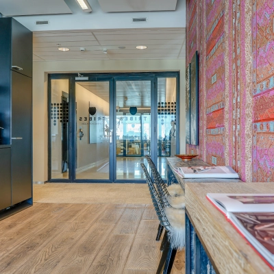 Kantoorpand in Amsterdam Zuid-Oost met kleurrijke wandbekleding en moderne koffiehoek. Perfect voor kantoorruimte huren. De stijl is eigentijds en uitnodigend, ideaal voor een professionele werkruimte.