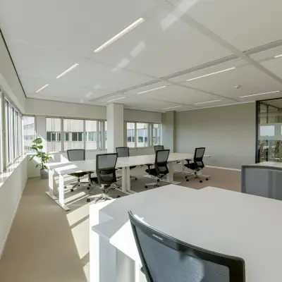 Moderne, lichte kantoorruimte op Herikerbergweg 288, Amsterdam Zuid-Oost te huur met strakke bureaus en ergonomische stoelen.