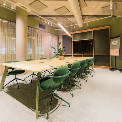 Moderne vergaderruimte in een kantoorpand aan de Hullenbergweg 109-135, Amsterdam Zuid-Oost, met een grote tafel en groene stoelen, ideaal voor kantoorruimte huren.