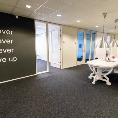 Kantoorruimte op Hullenbergweg 278, Amsterdam Zuid-Oost met een inspirerende muurtekst, moderne inrichting en vergadertafel. Ideale locatie voor kantoorruimte huren.
