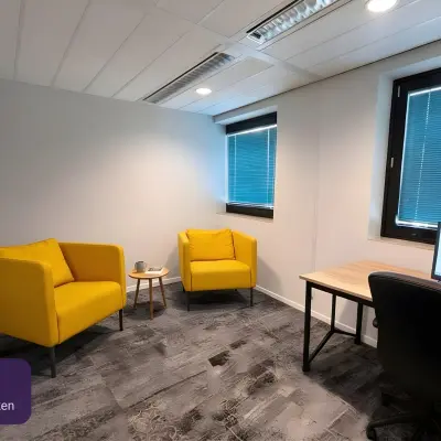 Moderne kantoorruimte huren op Johan Cruijff Boulevard 89, Amsterdam Zuid-Oost. De kamer is voorzien van frisse gele fauteuils, een bureau met computerscherm en veel daglicht via grote ramen.