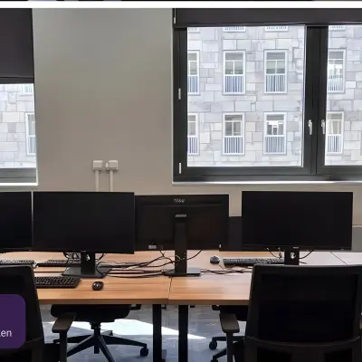 Moderne kantoorruimte huren op Johan Cruijff Boulevard 89, Amsterdam Zuid-Oost met grote ramen en meerdere werkplekken voorzien van beeldschermen en bureaustoelen.