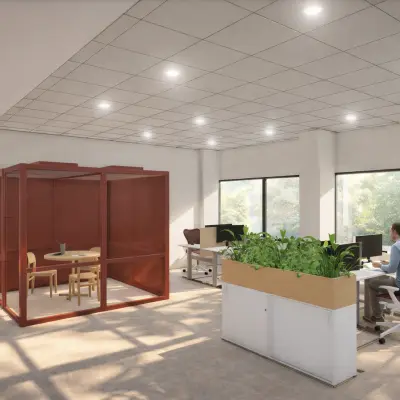 Kantoorruimte te huur in Amsterdam Zuid-Oost op Luttenbergweg 8 met moderne werkplekken en glazen vergaderruimte. Een persoon werkt aan een bureau in een lichte, groene omgeving.