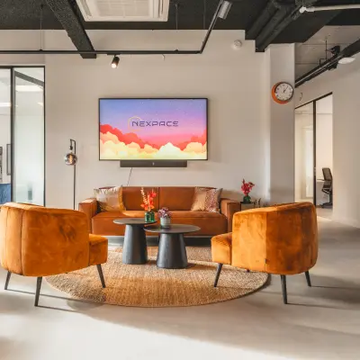 Moderne en stijlvol gemeubileerde kantoorruimte op Paasheuvelweg 20, Amsterdam Zuid-Oost, met comfortabele zitplaatsen en een groot scherm voor presentaties. Ideaal om een kantoorruimte te huren.