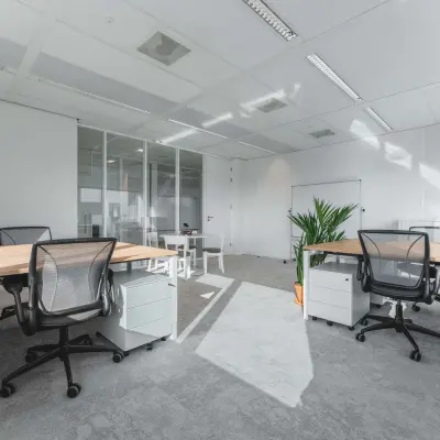Moderne kantoorruimte te huur op Barbara Strozzilaan 101, Amsterdam Zuidas, met strakke bureaus, bureaustoelen en veel natuurlijk licht door grote ramen.