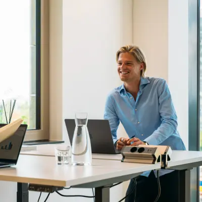 Zakelijke kantoorruimte op Beethovenstraat 503, met professionals in gesprek, ruime ramen en modern meubilair. Ideaal voor bedrijven die kantoorruimte willen huren in Amsterdam Zuidas.