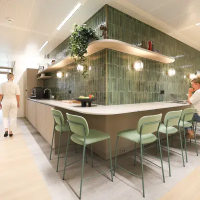 Moderne kantoorruimte huren aan Beethovenstraat 503 in Amsterdam Zuidas met een gemeubileerde kantoorpantry waar mensen zakelijke activiteiten uitvoeren.