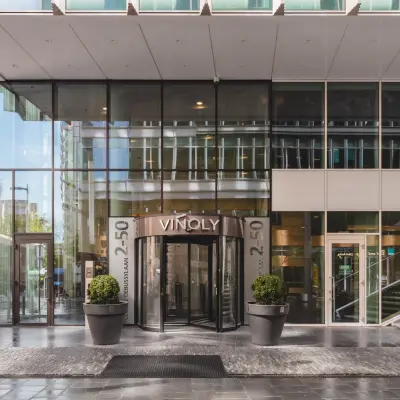 Voorzijde van kantoorpand op Claude Debussylaan 10 in Amsterdam Zuidas, met moderne glazen gevel. Geschikt voor kantoorruimte huren.