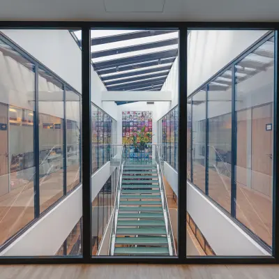 Overzicht van een modern kantoorpand op De Boelelaan 30 in Amsterdam Zuidas, met een glazen wand en een kleurrijk kunstwerk op de achtergrond.