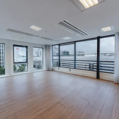 Ruime en lichte kantoorruimte te huur op De Boelelaan 30 in Amsterdam Zuidas, met grote ramen en een houten vloer. Perfect voor een open werkruimte.