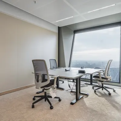 Kantoorruimte huren in Amsterdam Zuidas met uitzicht over de stad, voorzien van moderne bureaus en comfortabele stoelen, ideaal voor productieve werkuren.