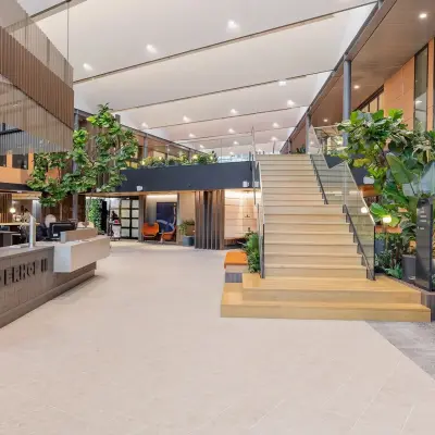 Stijlvolle kantoorruimte huren op Jachthavenweg 109, Amsterdam Zuidas, met moderne receptie en groene decoraties.