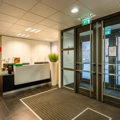 Kantoorpand op Het Rietveld 55-59, Apeldoorn, met een moderne entree en receptieruimte. De glazen deuren bieden toegang tot de kantoorruimte. Ideaal voor wie een kantoor wil huren.