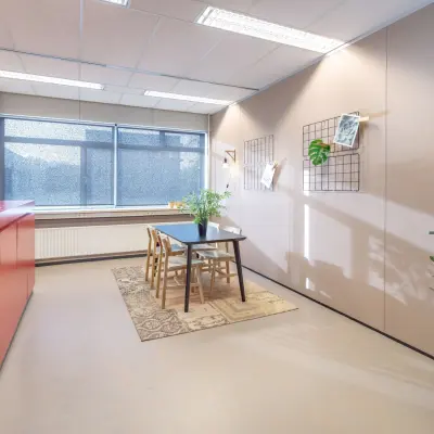 Kantoorpand op Oude Apeldoornseweg 41-45 in Apeldoorn met een moderne vergaderruimte inclusief tafel, stoelen en planten. Ideaal voor wie kantoorruimte wil huren.