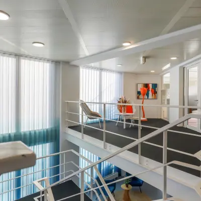 Moderne kantoorruimte te huur op de eerste verdieping van Prins Willem-Alexanderlaan 301 in Apeldoorn met strakke witte wanden en kunst aan de muur.