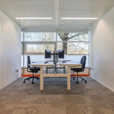 Kantoorruimte huren op Prins Willem-Alexanderlaan 301 in Apeldoorn met twee werkplekken, bureaus en stoelen, en veel natuurlijk licht.