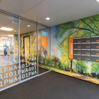 Entree van kantoorpand op Prins Willem-Alexanderlaan 401, Apeldoorn, met glazen deuren en boslandschapfotobehang op de muren. Ideaal voor kantoorruimte huren.