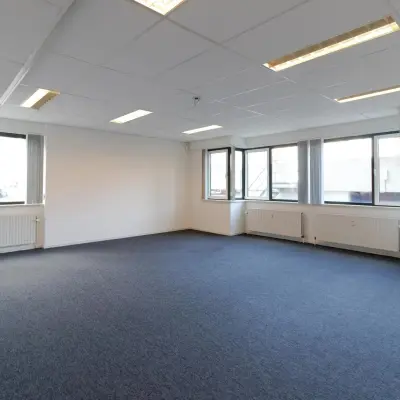 Leeg kantoorpand op Prins Willem-Alexanderlaan 401 in Apeldoorn, met ruime ramen en blauwe vloerbedekking, geschikt voor kantoorruimte huren.