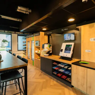 Moderne kantoorpand op Prins Willem Alexanderlaan 701, Apeldoorn, met een goed uitgeruste pantry en een lange tafel voor werk of bijeenkomsten, ideaal voor kantoorruimte huren.