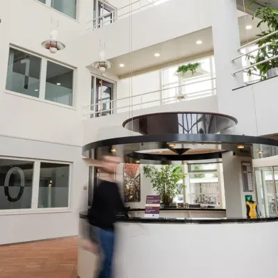 Lichte en ruime entree van een kantoorpand op Vlamoven 34 in Arnhem IJsseloord, met een receptiebalie en moderne uitstraling. Ideaal om kantoorruimte te huren in een dynamische omgeving.
