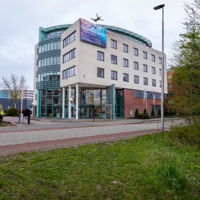 Moderne kantoorpand op Kronenburgsingel 525 in Arnhem Zuid, perfect voor kantoorruimte huren. Het gebouw heeft een glazen entree en meerdere verdiepingen, omgeven door groen.