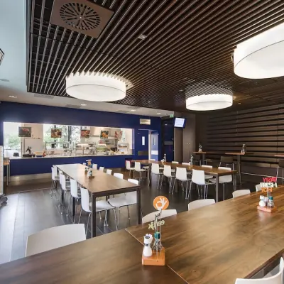 Binnenruimte in het kantoorpand op Kronenburgsingel 525, Arnhem Zuid met moderne tafels en een bedrijfskeuken. Ideaal voor kantoren die ruimte willen huren in een functionele omgeving.