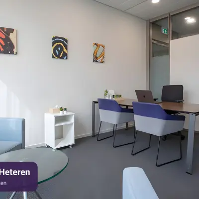 Moderne kantoorruimte te huur in Arnhem Zuid met strakke inrichting, inclusief vier werkplekken en kunstwerken aan de muur.