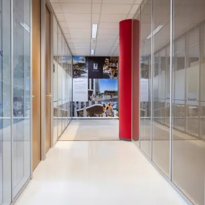 Heldere kantoorruimte in Baarn met glazen wanden en een rode kolom, gelegen aan Amalialaan 126. De ruimte biedt mogelijkheden voor kantoorruimte huren met een functionele uitstraling.