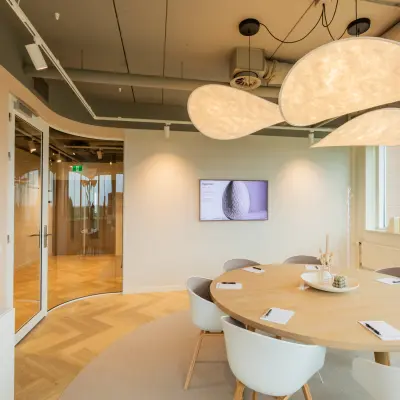 Moderne vergaderruimte in een kantoorpand op Baron van Nagellstraat 136, Barneveld. Voorzien van houten vloer, grote ovale tafel en designverlichting. Ideaal voor zakelijke bijeenkomsten en kantoorruimte huren.