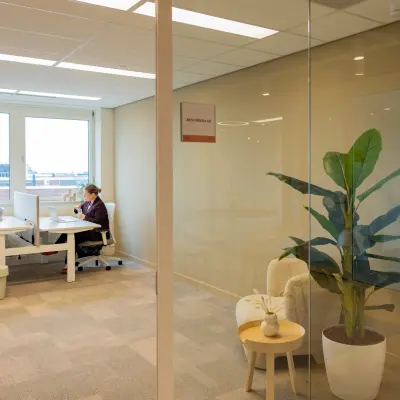 Heldere kantoorruimte op Baron van Nagellstraat 136, Barneveld, met moderne werkplekken en uitzicht. Twee mensen zijn aan het werk.