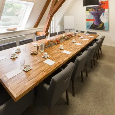 Vergaderruimte in kantoorpand Blokstallen 2B, Bergen op Zoom, met lange houten tafel en comfortabele stoelen, geschikt voor kantoorruimte huren.
