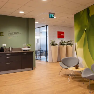 Moderne kantoorruimte op Marktstraat 1-7 in Bodegraven met groene wanden, ingerichte zithoek en koffiehoek. Ideaal voor bedrijven die kantoorruimte willen huren.