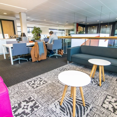 Moderne kantoorruimte op Ceresstraat 1 in Breda Centrum-Station met comfortabele zitgedeeltes en werkplekken. Een persoon werkt aan een bureau.