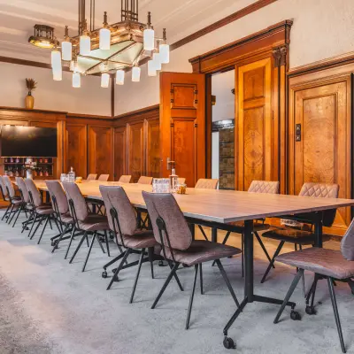 Ruime vergaderruimte in een kantoorpand op Ceresstraat 13, Breda Centrum-Station, met houten panelen, lange tafel en moderne stoelen.