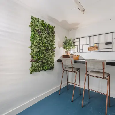 Kantoorruimte te huur op Ceresstraat 13, Breda Centrum-Station. Compacte ruimte met groene wanddecoratie en twee hoge stoelen aan een smalle tafel, ideale setting voor rustig werken.