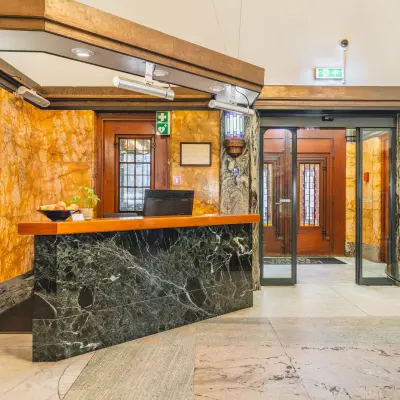 Inviting reception area in a kantoorpand at Ceresstraat 13, Breda Centrum-Station, perfect for kantoorruimte huren. Elegant design with marble details and warm lighting.