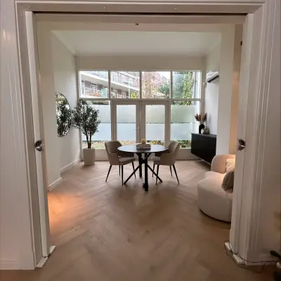 Moderne kantoorruimte in Breda Centrum-Station op Sophiastraat 40-40 met een neutraal interieur inclusief tafel en stoelen bij het raam. Ideaal voor bedrijven die een kantoorpand willen huren.