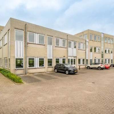 Exterieur van een kantoorpand op Regulierenring 2 in Bunnik, met geparkeerde auto's op de voorgrond, klaar voor kantoorruimte verhuur.