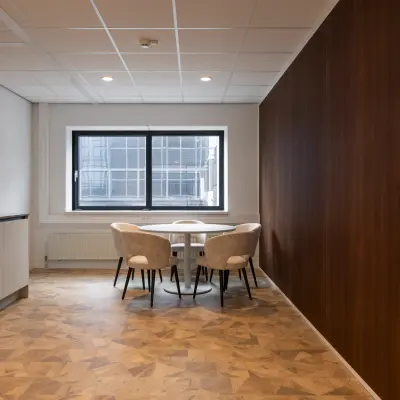 Kantoorruimte huren op Essebaan 63, Capelle aan den IJssel, met een moderne inrichting. De ruimte bevat een tafel met stoelen en een kitchenette.