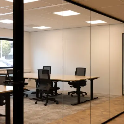Kantoorruimte met glazen wanden, voorzien van bureaus en stoelen, gelegen op Essebaan 63 in Capelle aan den IJssel. Deze stijlvolle kantooromgeving is klaar voor verhuur.