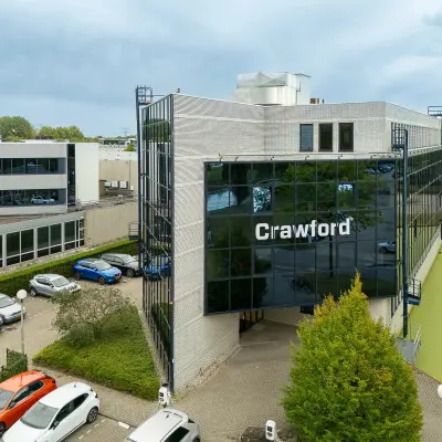 Modern kantoorpand aan Vlierbaan 20 in Capelle aan den IJssel met ruime parkeerplaats en groene omgeving. Voorzien van een glazen gevel en omgeven door groen.